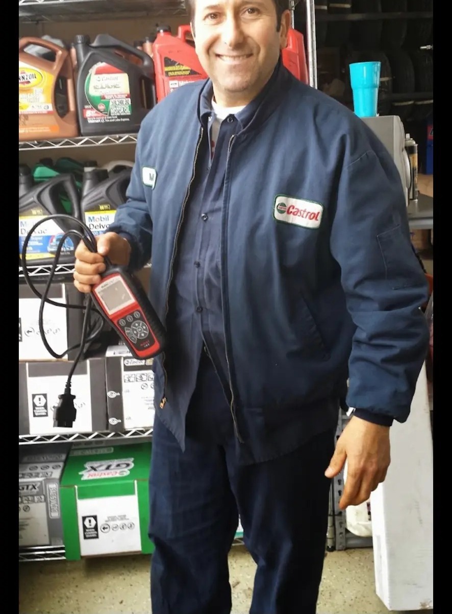 Owner holding a diagnostic scan tool inside the shop